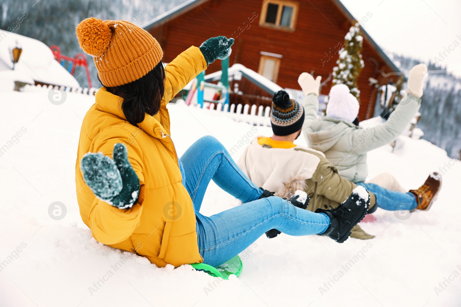 Photo of Group of friends having fun and sledding on snow. Winter vacation