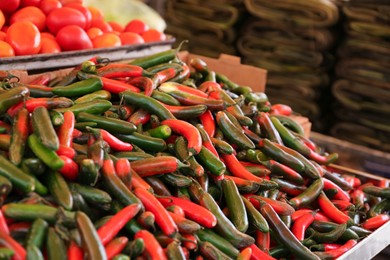 Photo of Heap of fresh Serrano peppers on counter at market, space for text