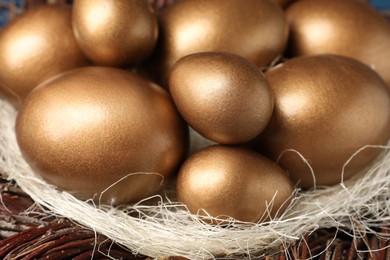 Many shiny golden eggs in nest, closeup