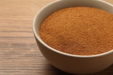 Photo of Bowl of chicory powder on wooden table, closeup