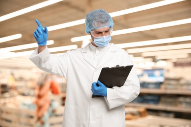 Image of Food quality control specialist examining products in supermarket