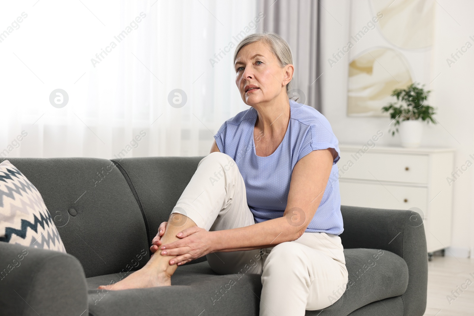 Photo of Arthritis symptoms. Woman suffering from pain in leg at home