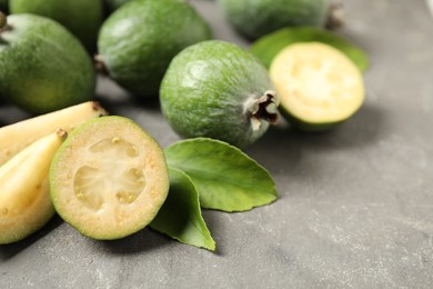 Fresh green feijoa fruits on grey table, closeup. Space for text