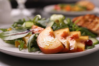 Photo of Delicious salad with peach slices on plate, closeup