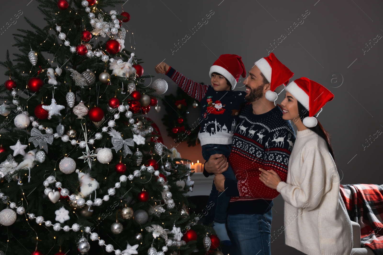 Photo of Happy family decorating Christmas tree together at home