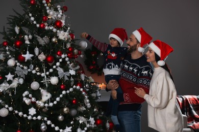 Happy family decorating Christmas tree together at home