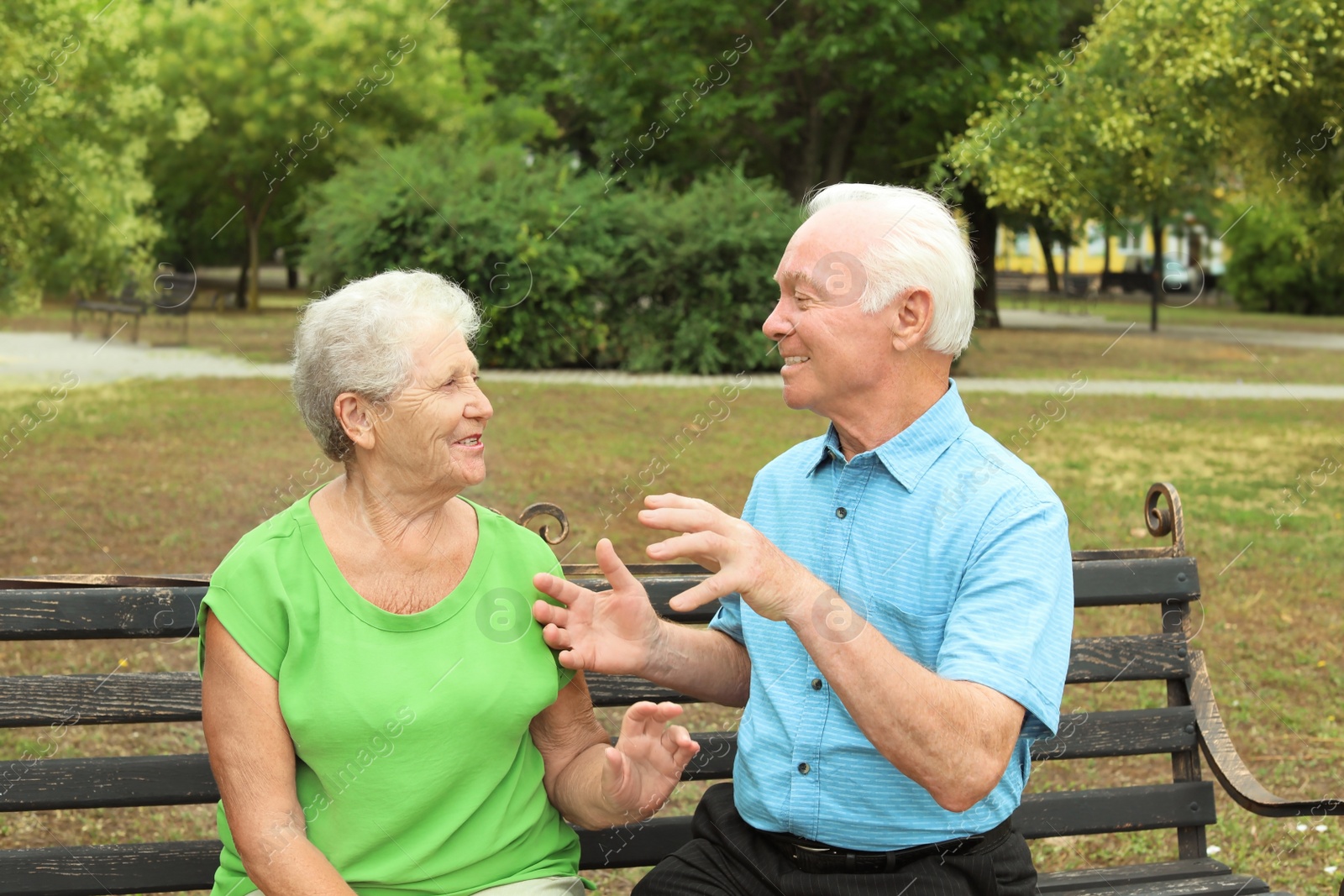 Photo of Elderly couple resting on bench in park