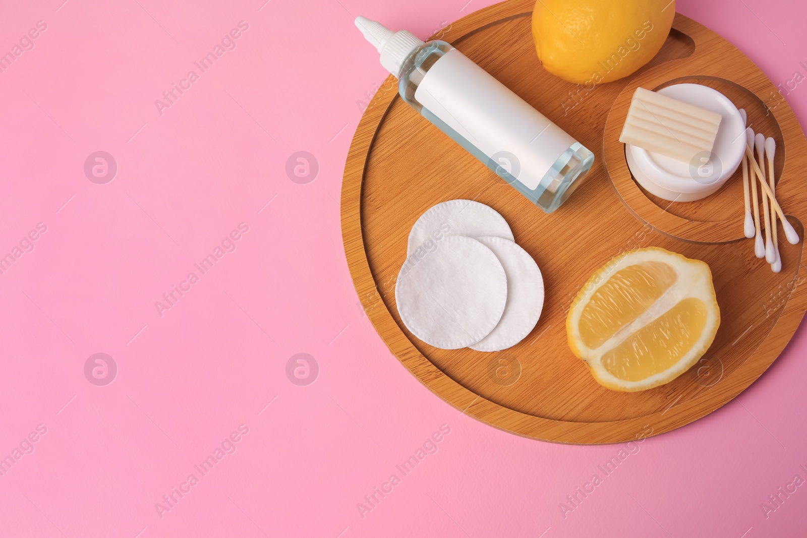 Photo of Lemon face cleanser. Fresh citrus fruits and personal care products on pink background, top view. Space for text