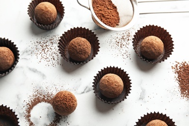 Flat lay composition with tasty raw chocolate truffles on marble background