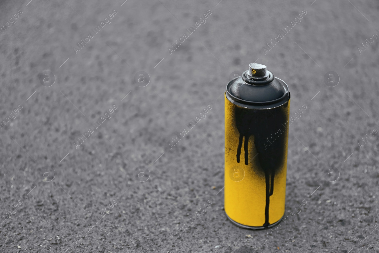 Photo of Used can of spray paint on asphalt. Space for text