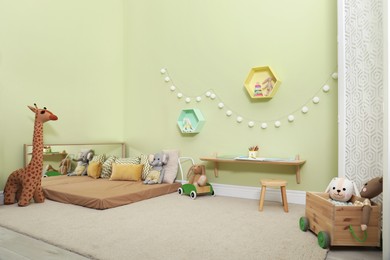 Photo of Montessori bedroom interior with floor bed and toys