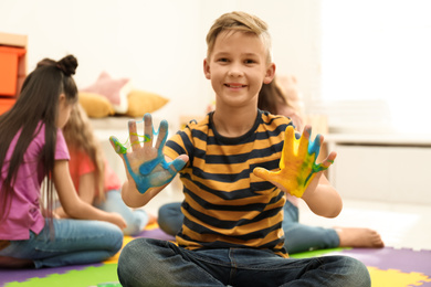 Preteen boy with slime in playroom, focus on hands