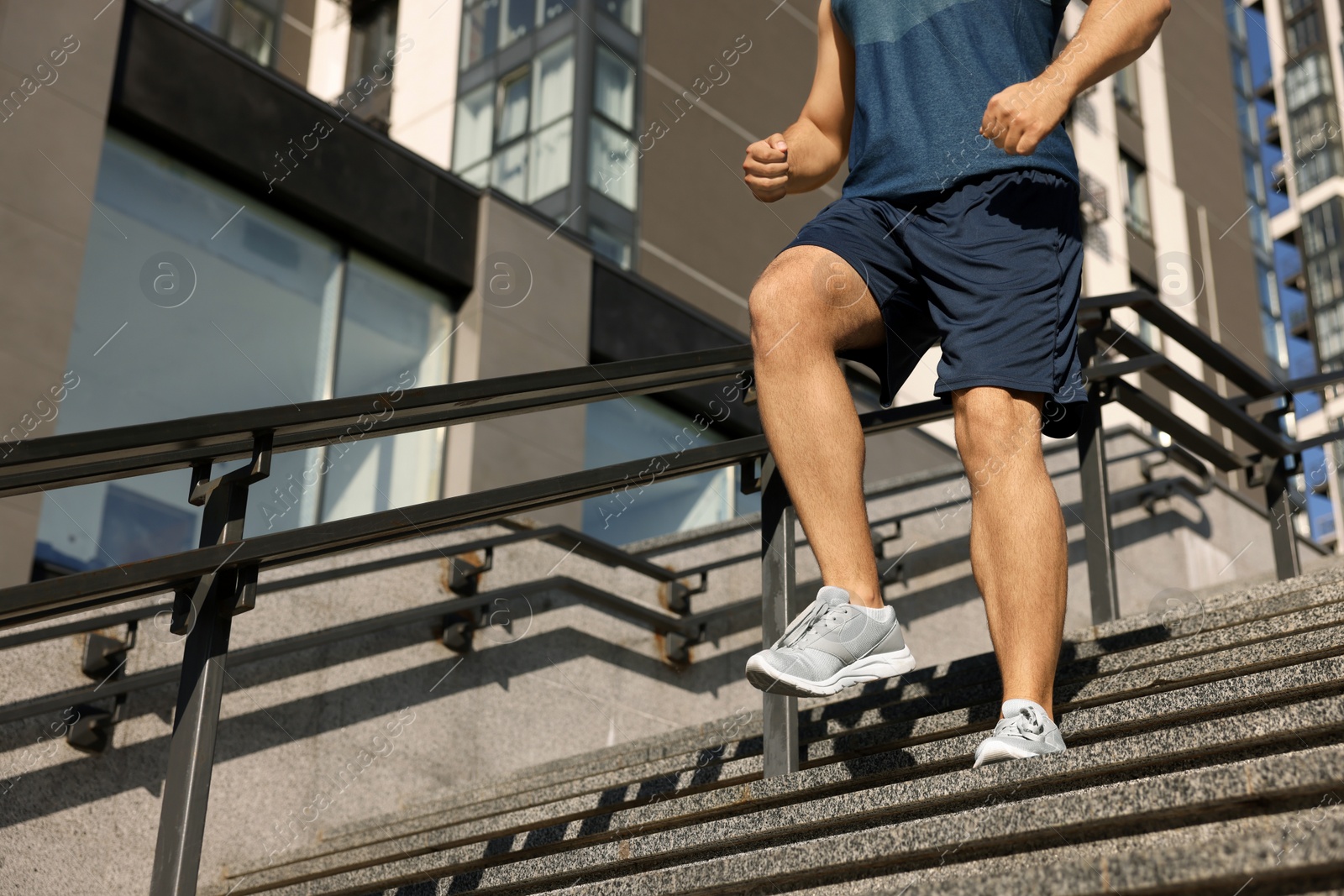 Photo of Man running down stairs outdoors on sunny day, closeup. Space for text