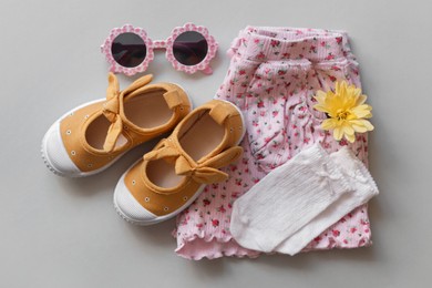 Photo of Stylish child clothes, shoes and accessories on grey background, flat lay