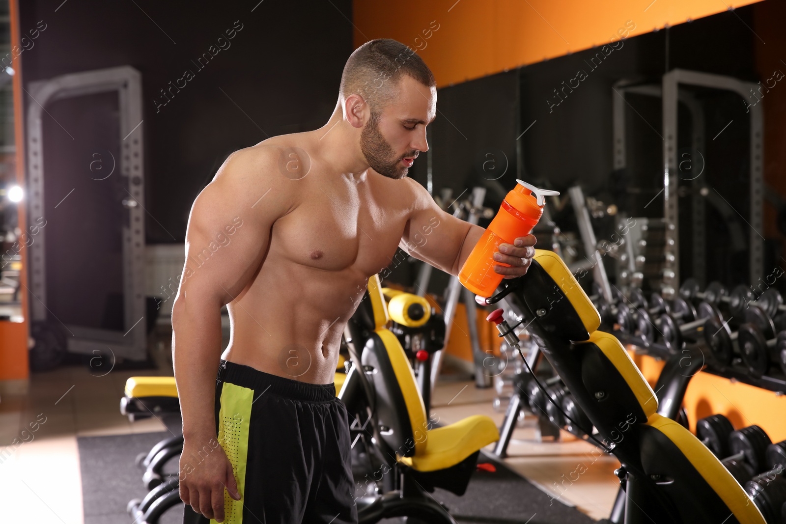 Photo of Portrait of athletic man with protein shake in gym