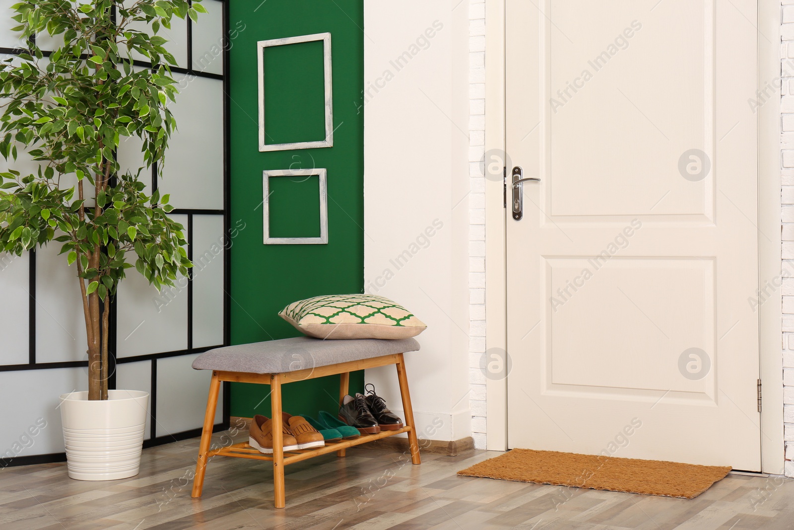 Photo of Stylish hallway interior with shoe storage bench and white door