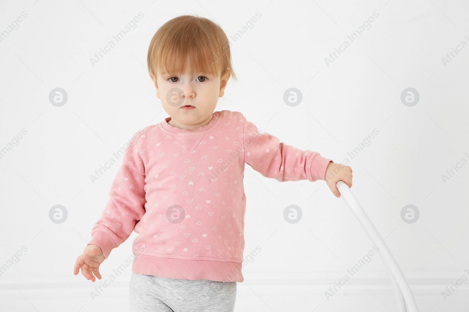 Photo of Cute baby playing with toy walker indoors