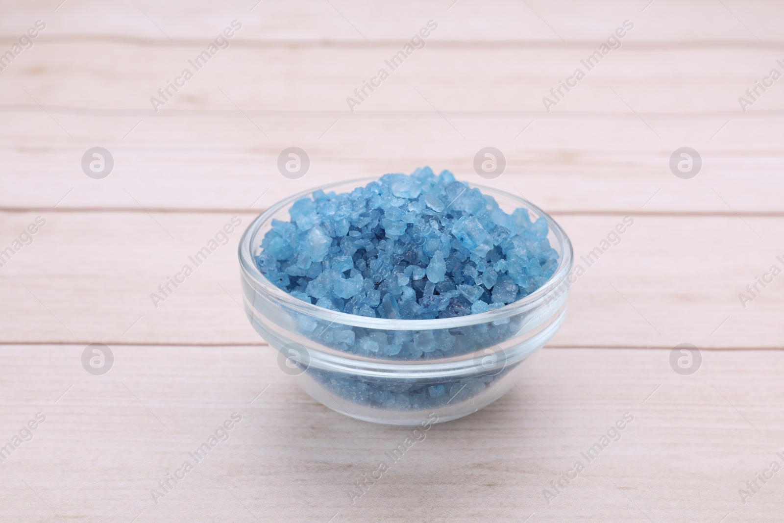 Photo of Blue sea salt in bowl on white wooden table