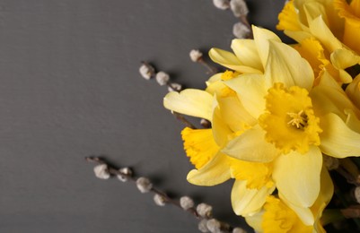 Photo of Beautiful yellow daffodils and willow twigs on blurred background, top view. Space for text