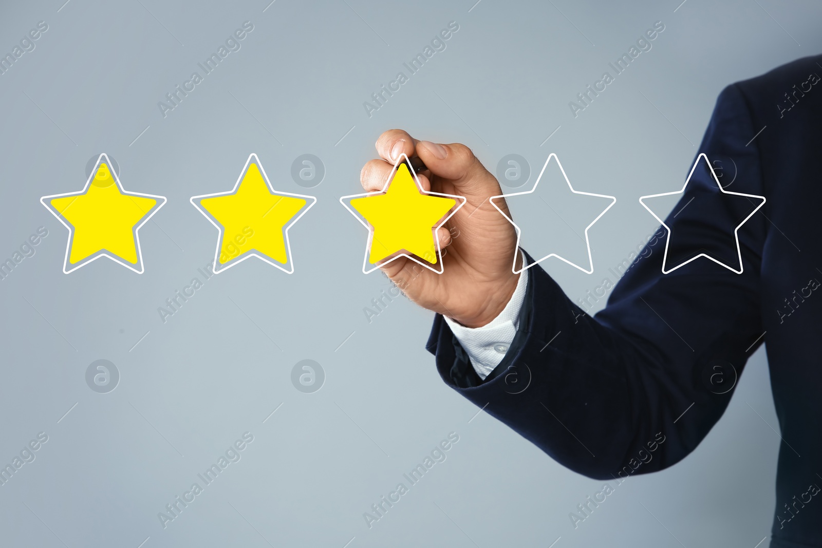 Image of Man pointing at icons of stars on light grey background, closeup. Quality rating