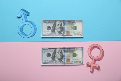 Gender pay gap. Male and female symbols with dollar banknotes on color background, flat lay