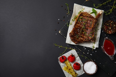 Photo of Flat lay composition with grilled meat on black background. Space for text