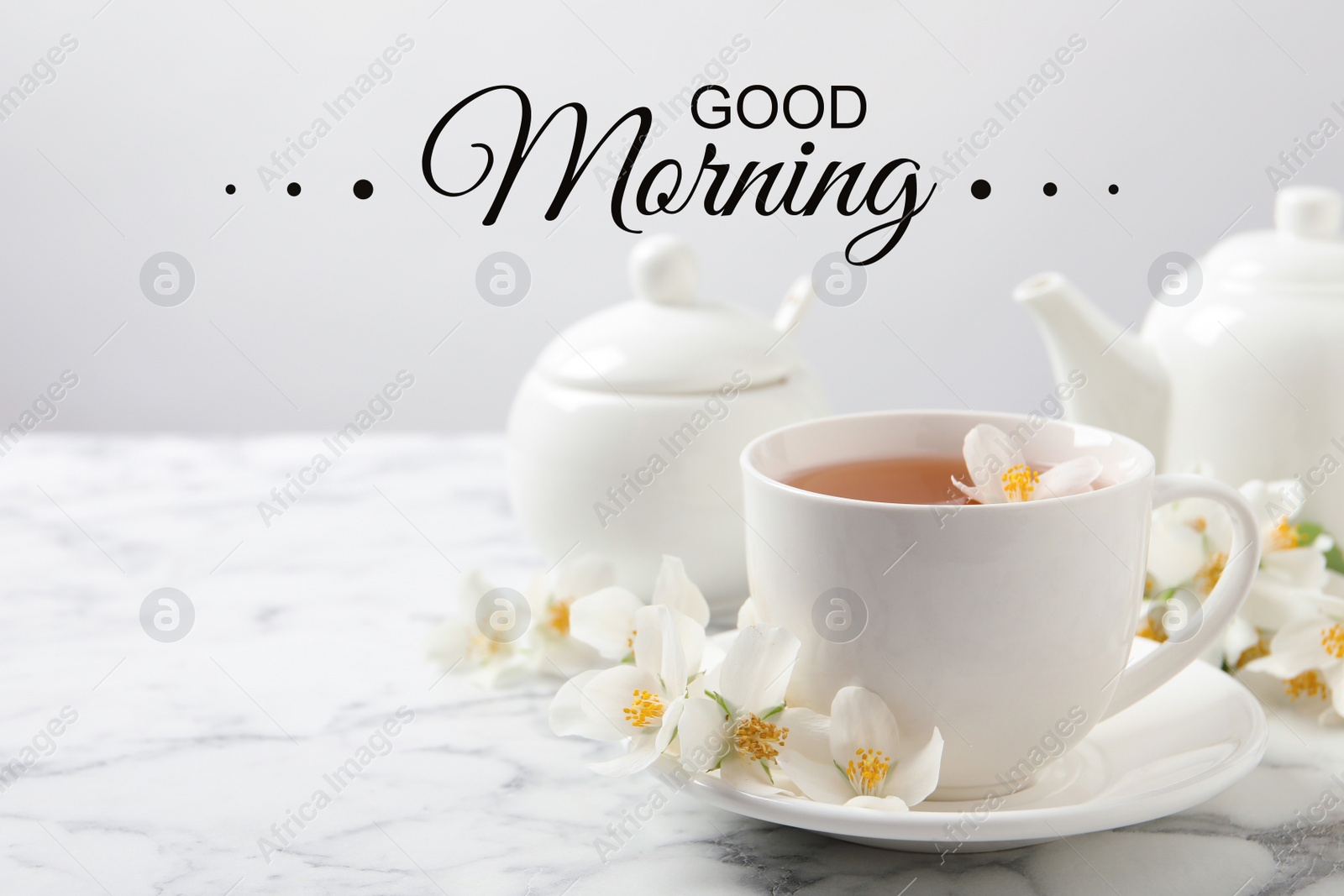 Image of Aromatic jasmine tea and fresh flowers on white marble table. Good morning