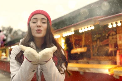 Young woman spending time at Christmas fair, space for text