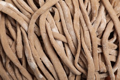 Photo of Uncooked homemade soba (buckwheat noodles) as background, top view