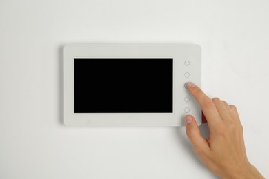 Photo of Woman using modern video intercom indoors, closeup