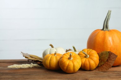 Photo of Thanksgiving day. Composition with many different pumpkins on wooden table, space for text