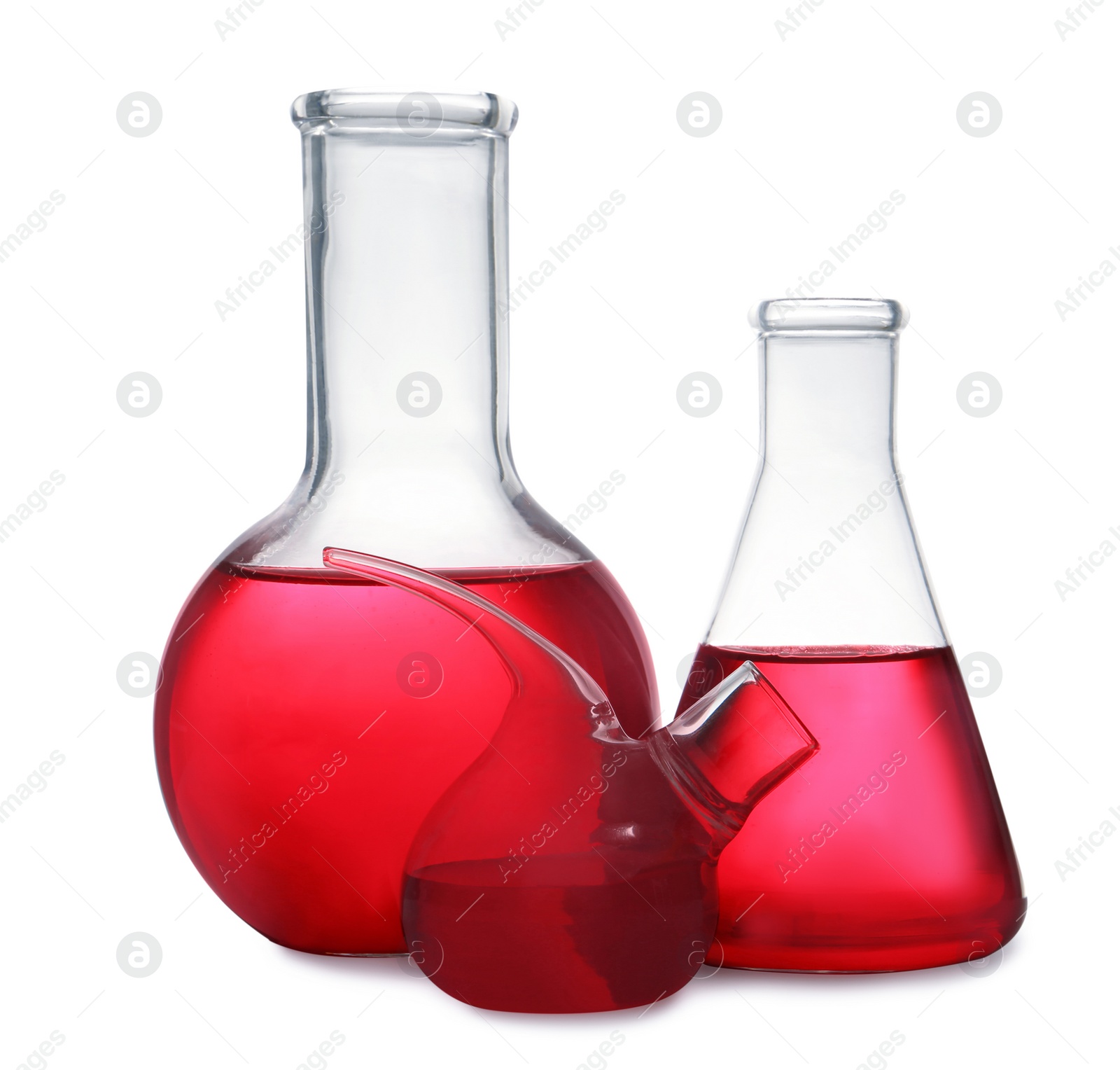 Photo of Set of laboratory glassware with red liquid on white background