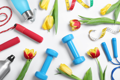 Photo of Composition with spring flowers and sports items on white background, top view