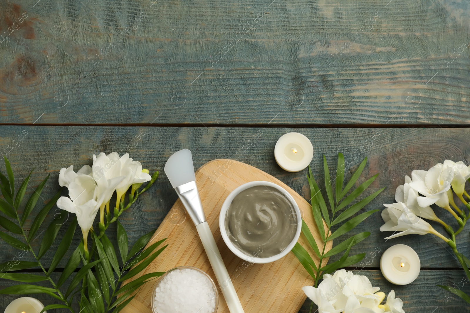 Photo of Flat lay composition with cosmetic product on light blue wooden background, space for text. Spa body wraps