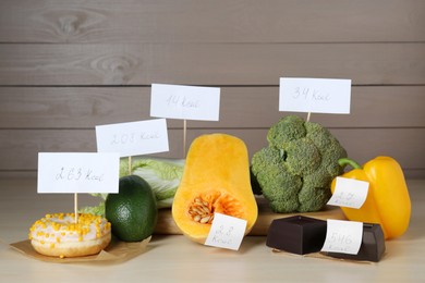 Food products with calorific value tags on wooden table. Weight loss concept