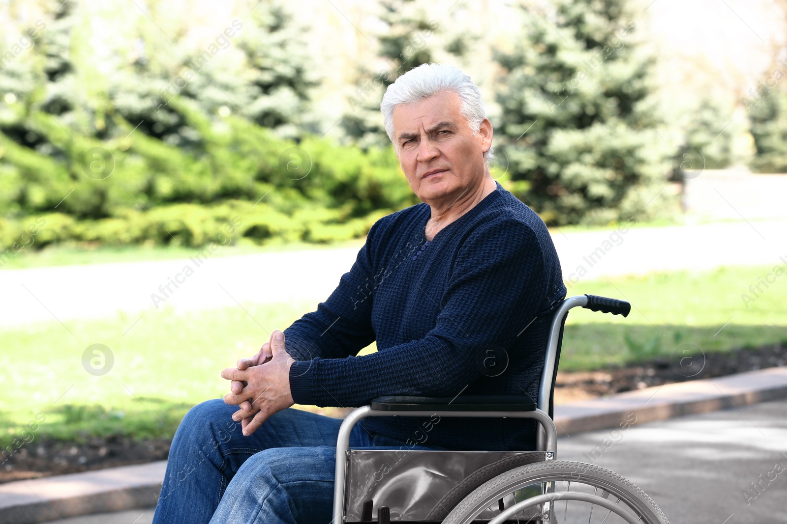 Photo of Senior man in wheelchair at park on sunny day