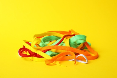 Photo of Different colorful shoe laces on yellow background