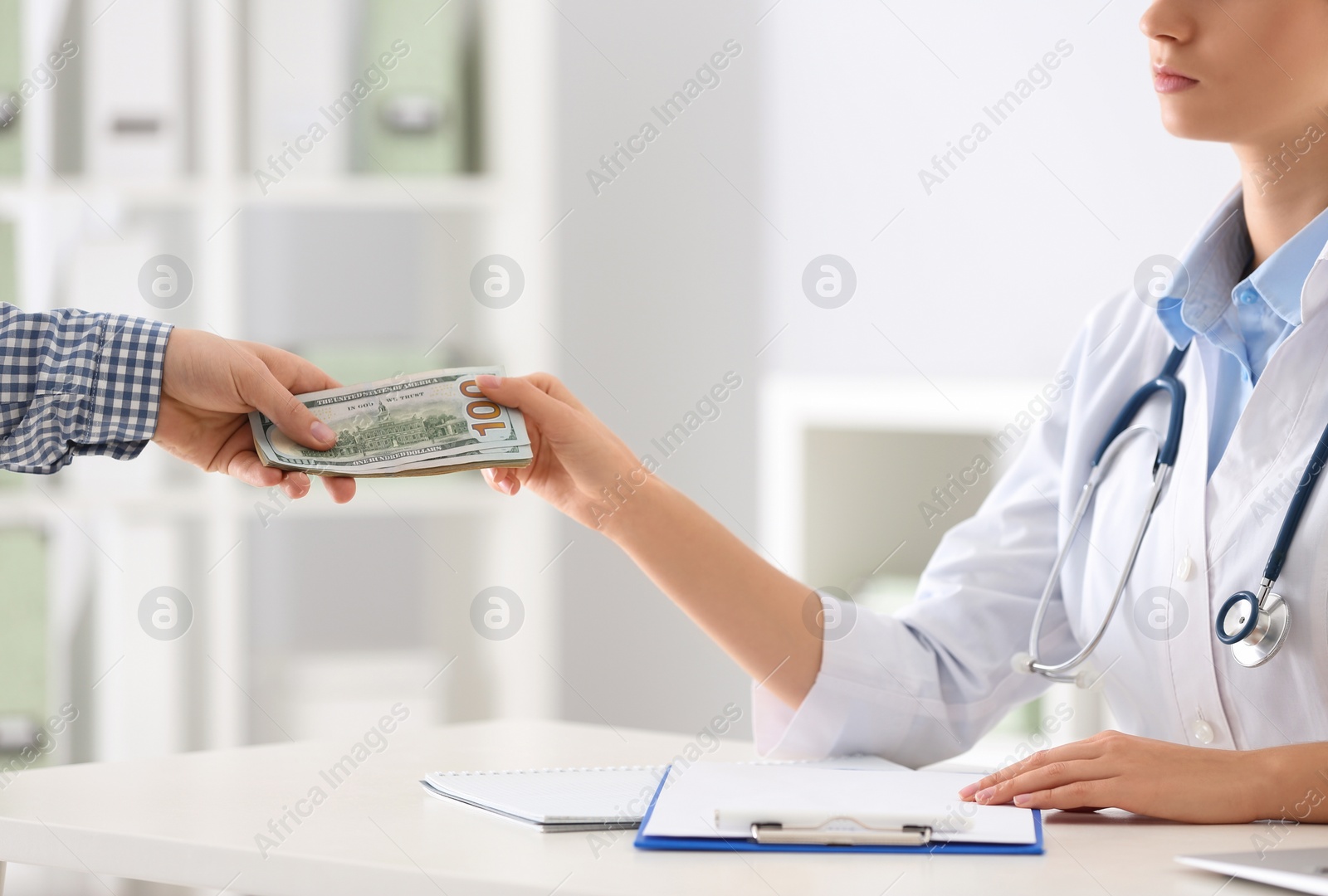 Photo of Patient giving bribe to doctor in clinic, closeup. Corrupted medicine