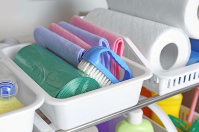 Photo of Different cleaning supplies in plastic boxes, closeup