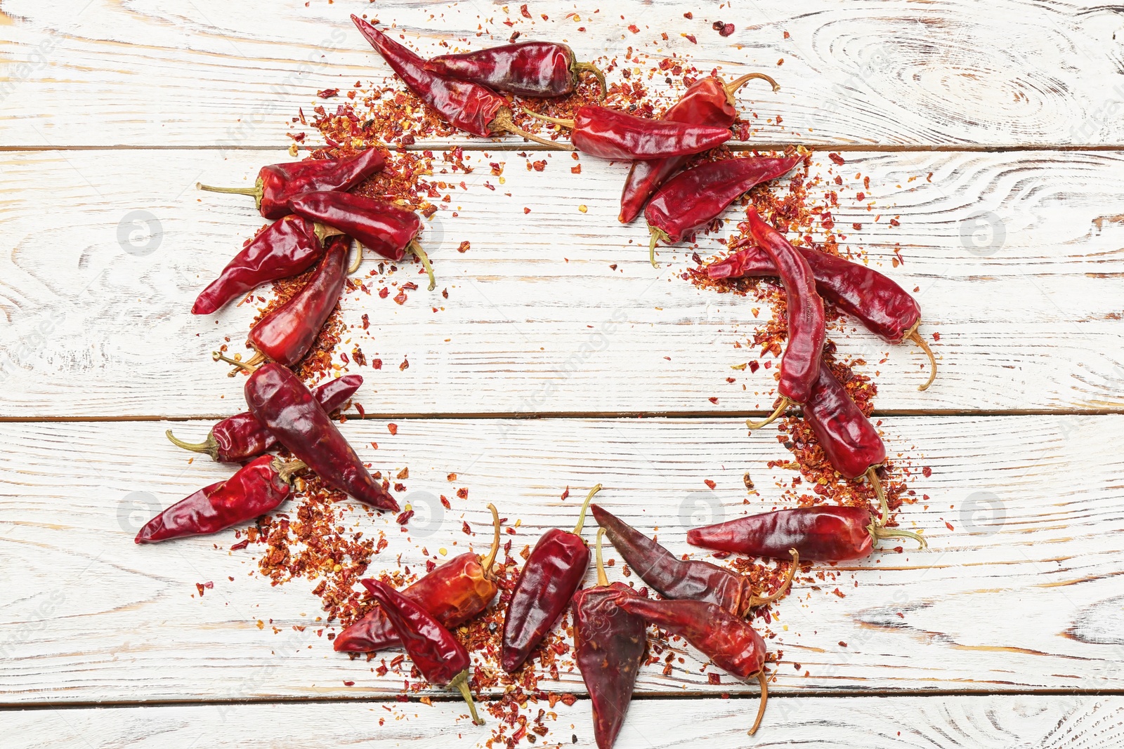 Photo of Composition with dry chili peppers and flakes on wooden background