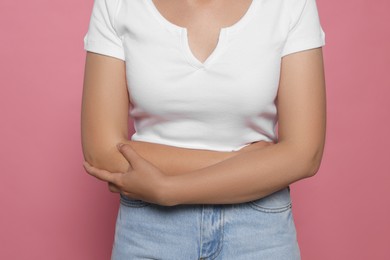 Photo of Young woman suffering from menstrual pain on pink background, closeup