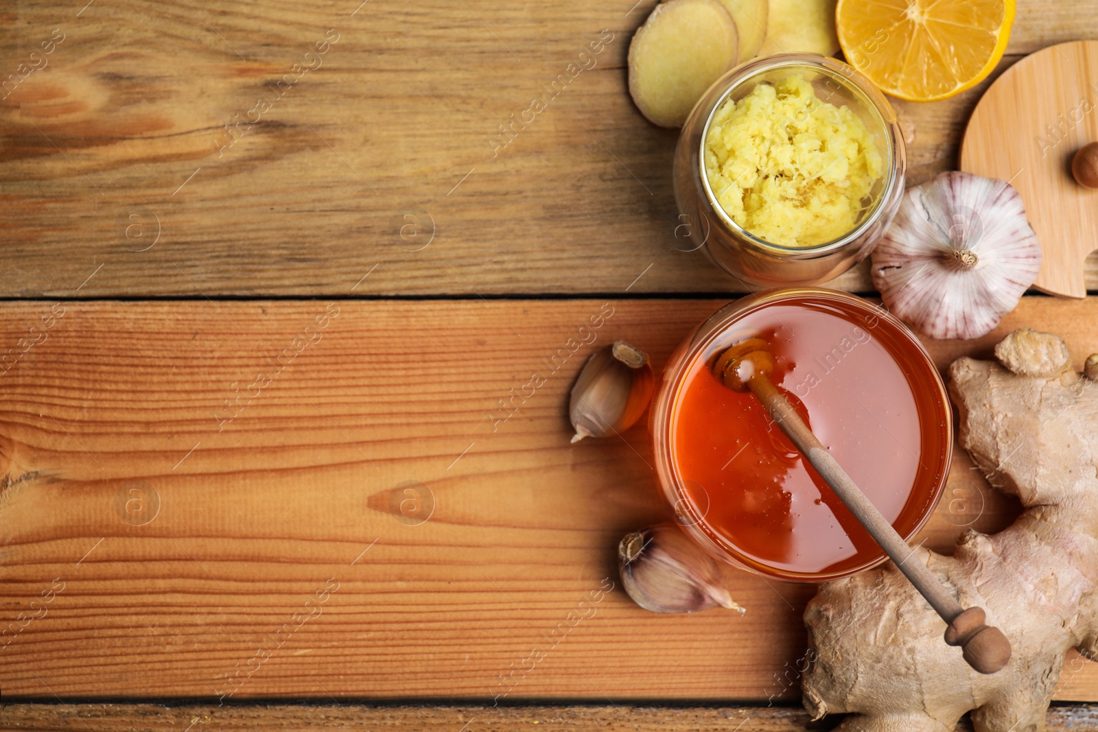 Photo of Fresh garlic and other natural cold remedies on wooden table, flat lay. Space for text