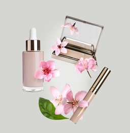 Image of Spring flowers and makeup products in air on light grey background