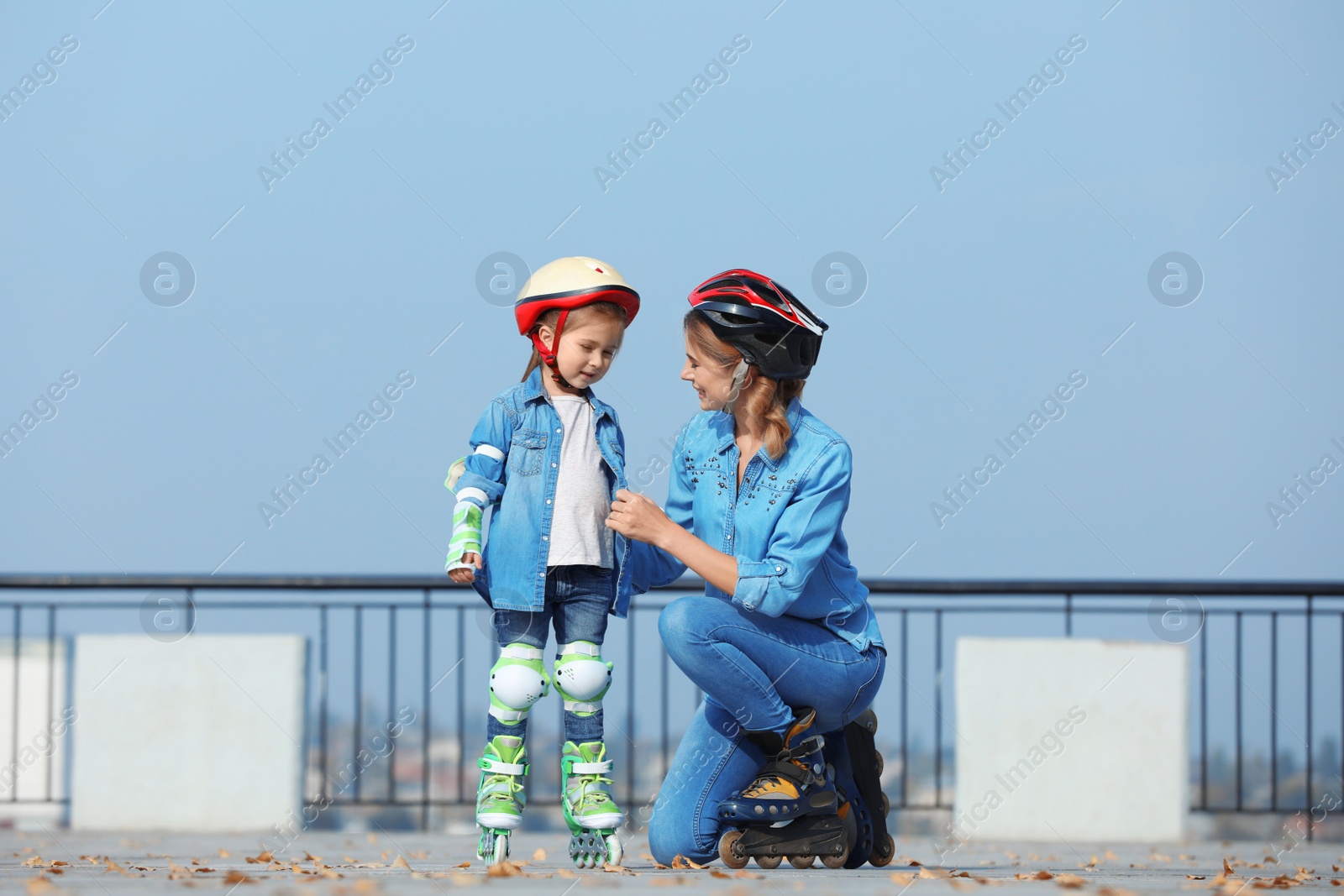 Photo of Mother and her daughter wearing roller skates on city street