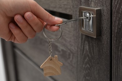 Photo of Woman unlocking door with key, closeup view