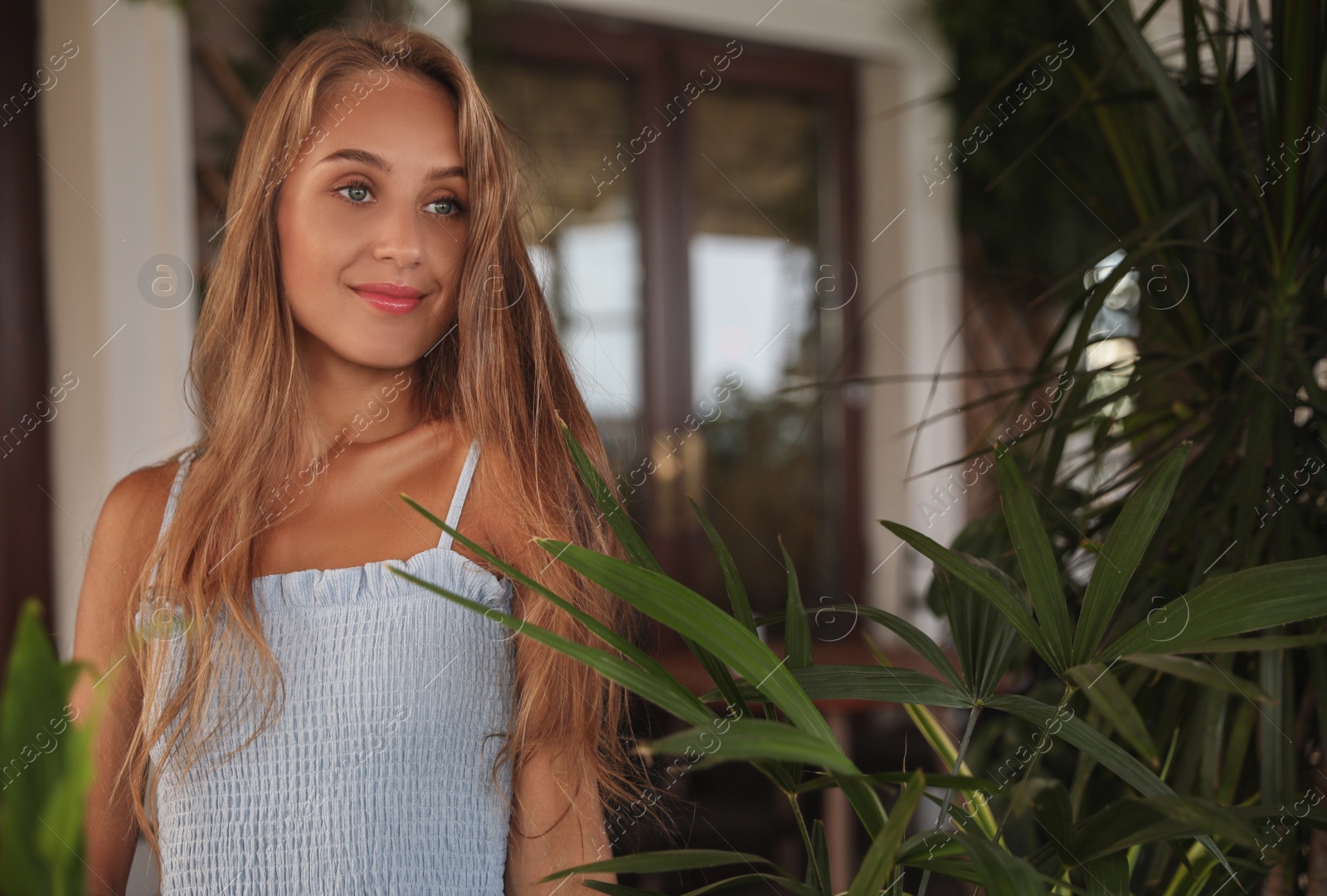 Photo of Beautiful young woman standing on indoor terrace