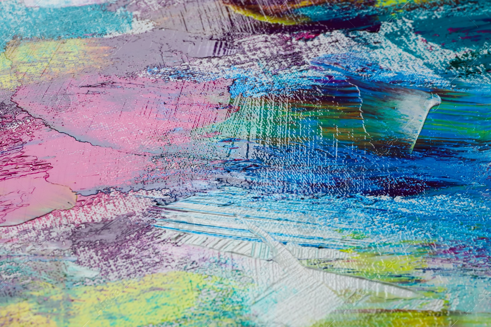 Photo of Strokes of colorful acrylic paints on canvas, closeup