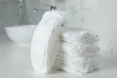 Stack of baby diapers on counter in bathroom