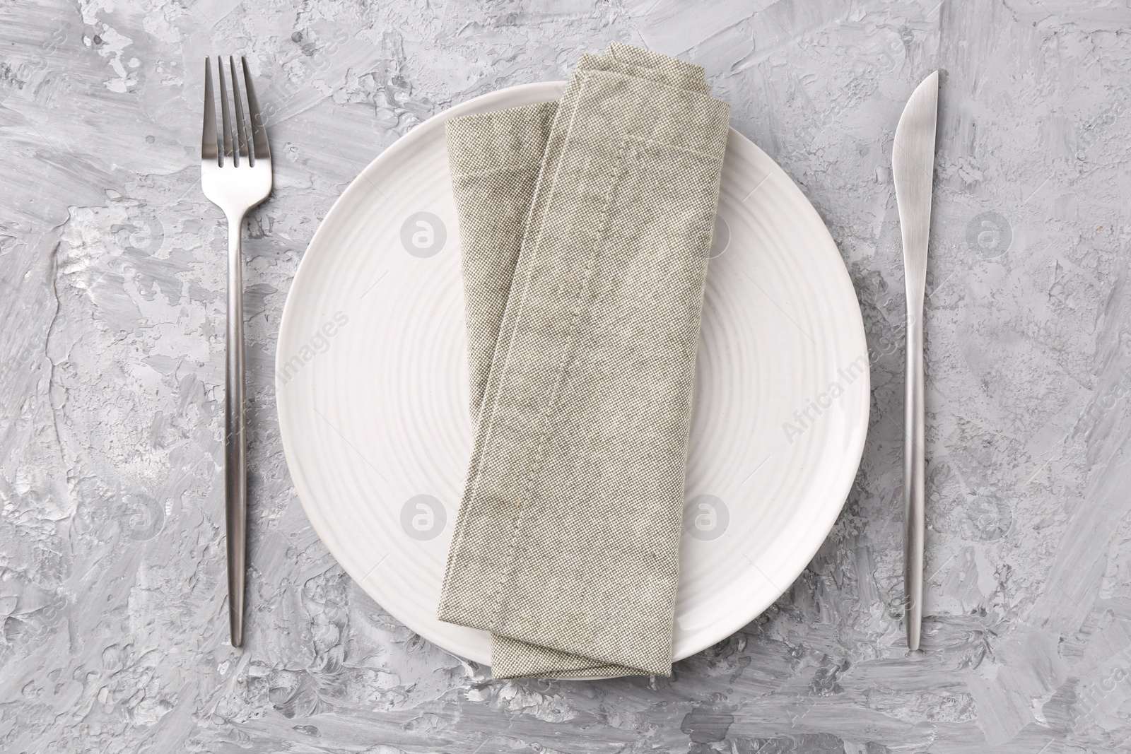 Photo of Elegant setting with silver cutlery on grey textured table, flat lay