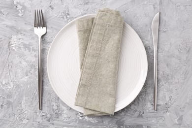 Photo of Elegant setting with silver cutlery on grey textured table, flat lay